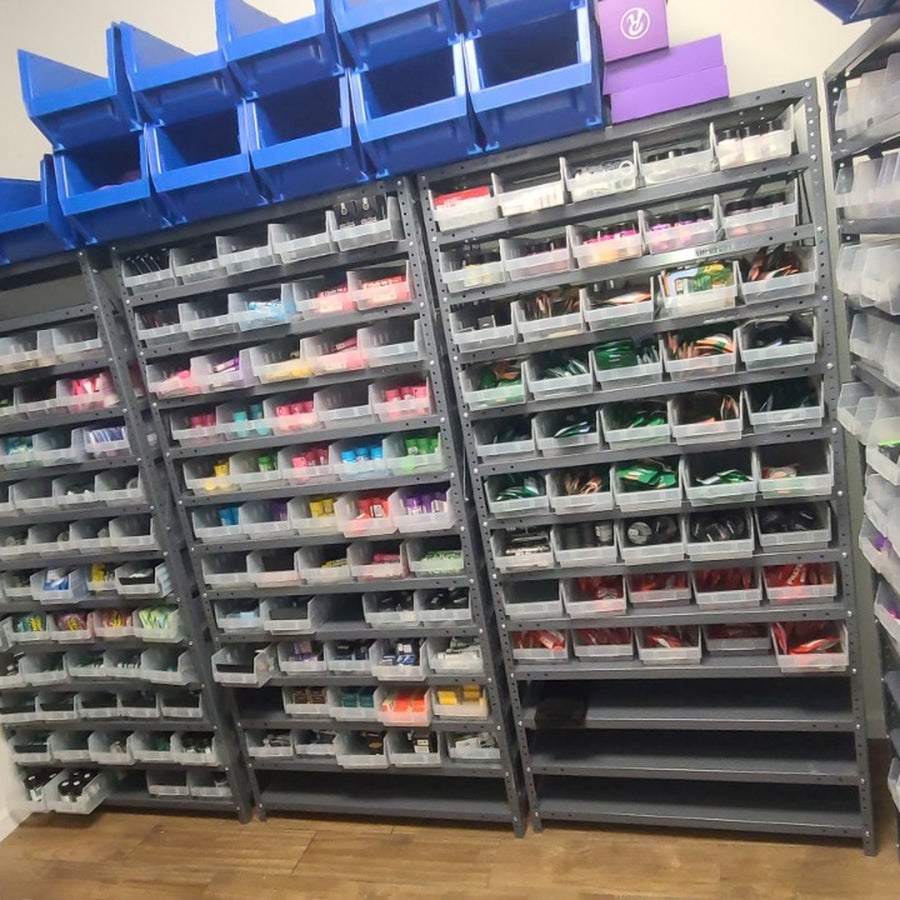 Clear-bin shelving throughout a dispensary inventory room.