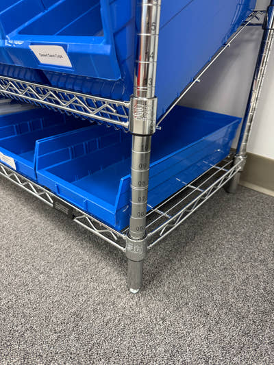 Blue plastic shelf bins on chrome wire shelving