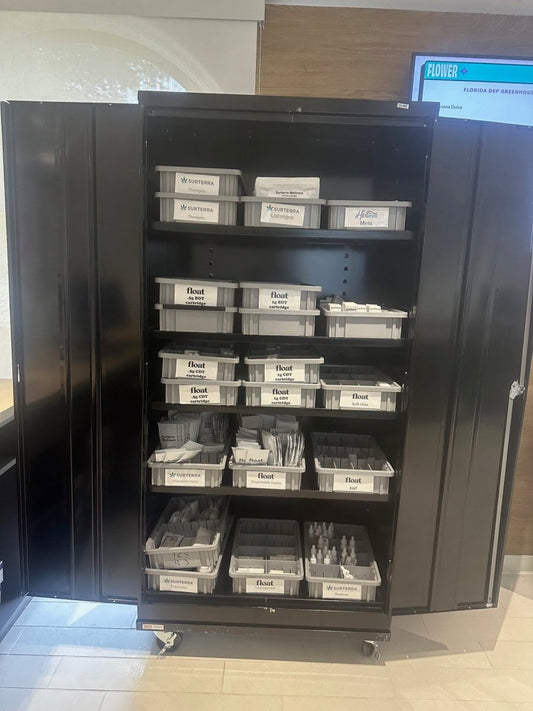 Gray dividable grid containers organizing products in a dispensary storage cabinet 1