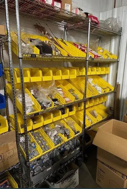 Yellow Shelf Bins on Slanted Wire Shelving in Inventory Closet